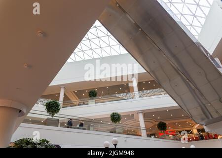 Grodno, Bielorussia - 01 settembre 2020: I visitatori camminano attraverso i piani e si spostano su scale mobili e ascensori nel centro commerciale Triniti. Foto Stock