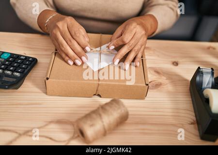 Medio età ispanica donna ecommerce business worker preparare il pacchetto in ufficio Foto Stock