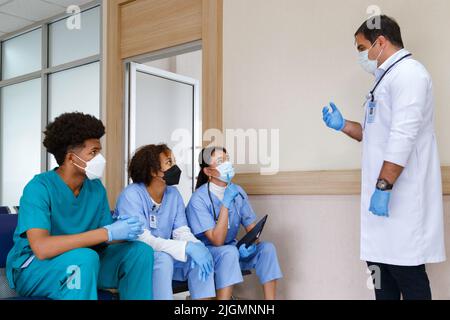 professore medico dare consiglio e discutere con il team intern studente per la pianificazione della chirurgia e il trattamento del paziente nella scuola medica ospedale Foto Stock