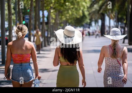 Barcellona, Spagna. 11th luglio 2022. I turisti sono visti sul molo di Barceloneta dirigendosi verso la spiaggia che indossa abbigliamento da spiaggia e cappelli. Seconda ondata di calore estremo che può superare i 44 gradi Celsius in alcune regioni della Spagna. La Catalogna, attualmente al livello uno e dopo settimane di accumulo di alte temperature e di poca pioggia, soffrirà questa settimana alcuni giorni di temperature al di sopra di quanto è solito per queste date Credit: SOPA Images Limited/Alamy Live News Foto Stock