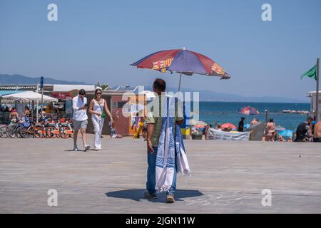Barcellona, Spagna. 11th luglio 2022. Un venditore di ombrelloni è visto sulla spiaggia a Barceloneta seconda ondata di calore estremo che può superare i 44 gradi Celsius in alcune regioni della Spagna. La Catalogna, attualmente al livello uno e dopo settimane di accumulo di alte temperature e di poca pioggia, soffrirà questa settimana alcuni giorni di temperature al di sopra di quanto è solito per queste date Credit: SOPA Images Limited/Alamy Live News Foto Stock