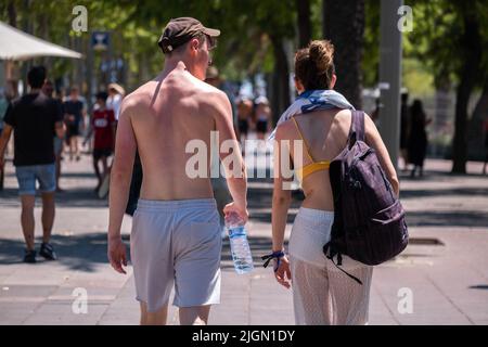 Barcellona, Spagna. 11th luglio 2022. I turisti sono visti sul molo di Barceloneta dirigendosi verso la spiaggia indossando il beachwear. Seconda ondata di calore estremo che può superare i 44 gradi Celsius in alcune regioni della Spagna. La Catalogna, attualmente al livello uno e dopo settimane di accumulo di alte temperature e di poca pioggia, soffrirà questa settimana alcuni giorni di temperature al di sopra di quanto è solito per queste date (Foto di Paco Freire/SOPA Images/Sipa USA) Credit: Sipa USA/Alamy Live News Foto Stock