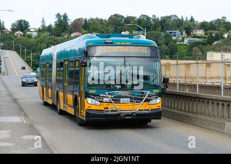 Seattle - 09 luglio 2022; autobus metropolitano Teal e arancione a tre porte King County che attraversano il Magnolia Bridge a Seattle Foto Stock