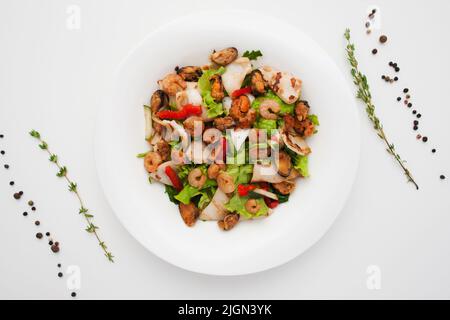 Insalata calda con piatti di pesce alla griglia Foto Stock