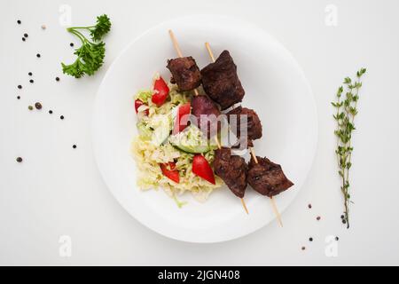 Appetitoso shashlik con insalata su piatto di posa piatto Foto Stock