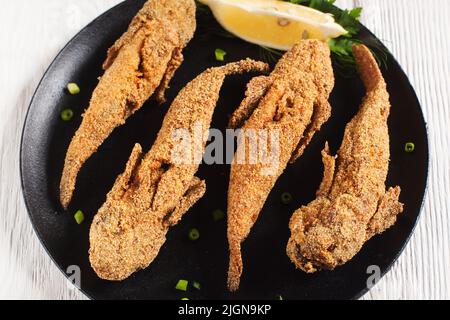 Pesce gby fritto su piatto nero Foto Stock