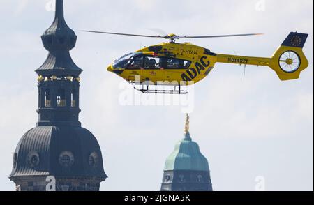 Dresda, Germania. 12th luglio 2022. L'elicottero di salvataggio e terapia intensiva 'Christoph' dell'ADAC Air Rescue Service atterra di fronte alla città vecchia con la Torre Hausmann (l) e il municipio. Oggi, presso il Centro Congressi Internazionale (ICC) si svolge il "Symposium Sassonia" di ADAC Luftrettung sulle sfide attuali e gli sviluppi della rapida assistenza aerea. Credit: Robert Michael/dpa/Alamy Live News Foto Stock