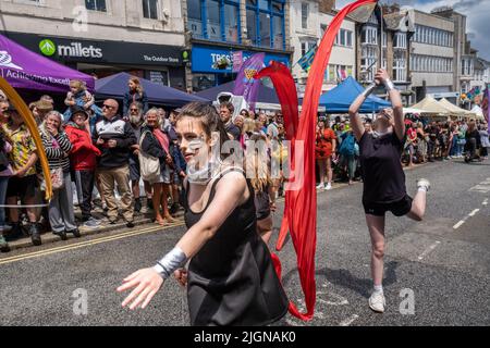 Gli studenti della scuola ballano a nastro nella sfilata del Mazey Day come parte del Festival di Golowan a Penzance in Cornovaglia nel Regno Unito. Foto Stock