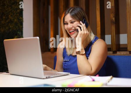 Donna Entreveneur che parla al telefono così felice con un portatile Foto Stock