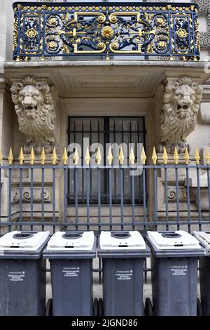 una fila di bidoni della spazzatura comunali standard grigi e bianchi allineati su un marciapiede lungo Rue de Rivoli a Parigi, Francia Foto Stock