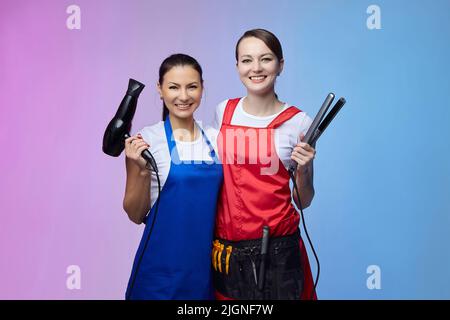 due ragazze-parrucchieri in officina. Aspetto asiatico e caucasico. Foto Stock