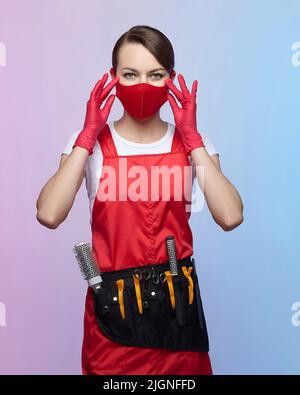 ragazza parrucchiere in maschera rossa e guanti Foto Stock