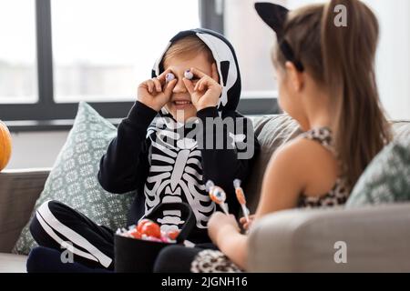 bambini in costumi di halloween con caramelle a casa Foto Stock