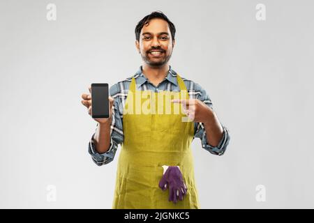 uomo indiano giardiniere o agricoltore con smartphone Foto Stock