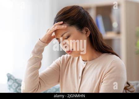 donna asiatica malata che ha mal di testa a casa Foto Stock