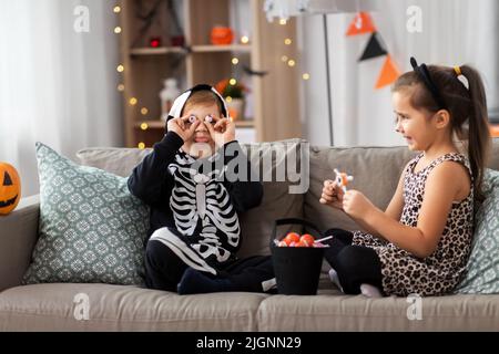 bambini in costumi di halloween con caramelle a casa Foto Stock