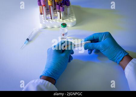 Mani del medico che tiene il flaconcino con il virus del scimmipox Foto Stock