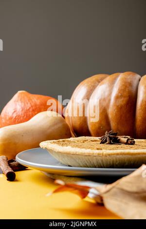 Composizione di foglie autunnali, zucche, spezie e torta su sfondo grigio Foto Stock