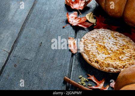 Composizione di foglie autunnali, zucche, spezie e torta su sfondo di legno Foto Stock