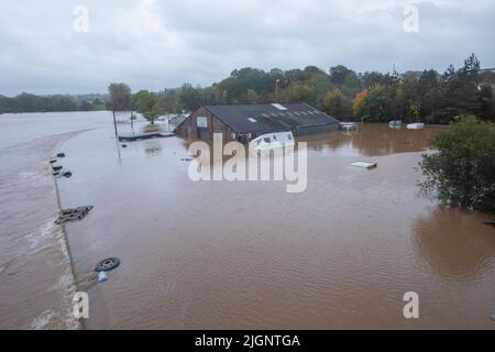 River Towy supera le difese delle alluvioni e inonda il garage di Ken Williams durante Storm Callum 2018, Galles, Regno Unito Foto Stock
