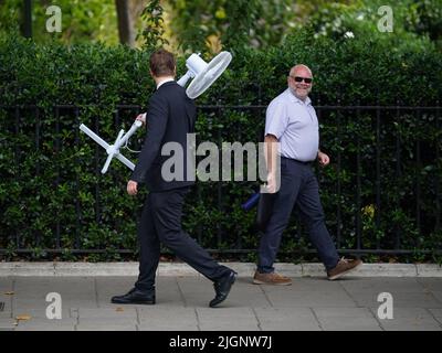 Un lavoratore d'ufficio porta un grande fan attraverso Westminster, centro di Londra. L'ufficio MET ha emesso un avvertimento di colore ambra per il surriscaldamento eccessivo in alcune parti del Regno Unito, prima che questa settimana si innalzano ulteriormente le temperature. Data foto: Martedì 12 luglio 2022. Foto Stock