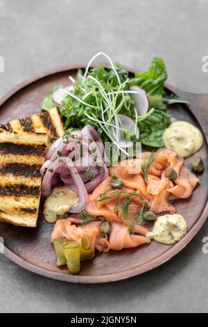 piatto di salmone gravlax con insalata e toast su sfondo grigio in svezia Foto Stock