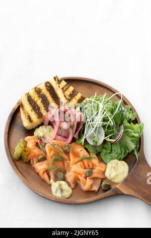 piatto di salmone gravlax con insalata e toast su sfondo bianco in svezia Foto Stock