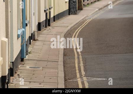 Due linee gialle su una strada laterale a Sidmouth, Devon. Le strade sono molto strette e non è consentito parcheggiare Foto Stock