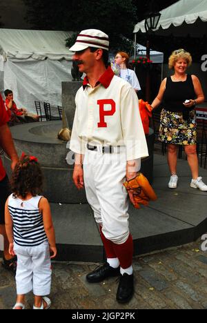 Un uomo adulto si veste in un costume da Baseball Old Time uniforme che insegna ai bambini dello sport durante la fine del 20th secolo a Filadelfia Foto Stock