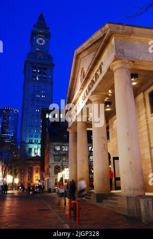 Le luci dello storico Quincy Market e Custom House di Boston sono illuminate e riflesse nelle strade della città in una piovosa giornata invernale al tramonto Foto Stock