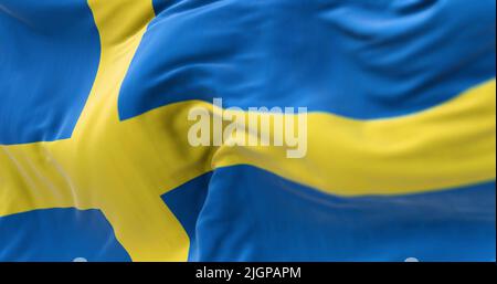 Vista ravvicinata della bandiera nazionale svedese che sventola nel vento. Paese scandinavo situato nel nord Europa Foto Stock