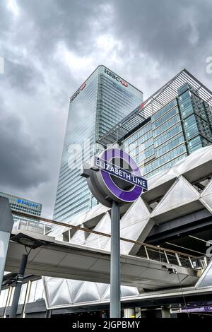 Insegna a Canary Wharf per la nuova metropolitana Elizabeth Line di Londra. Dietro ci sono i grattacieli per le banche HSBC e Barclays. Foto Stock