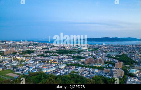 Vista aerea della città di Akashi e dell'isola di Awaji con ponte in lontananza all'ora blu Foto Stock