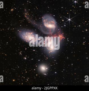 12 luglio 2022: Stephan's Quintet, un gruppo visivo di cinque galassie, è meglio conosciuto per essere presentato in modo preminente nel film classico delle vacanze, 'IT's a Wonderful Life'. Oggi, il telescopio spaziale James Webb della NASA rivela il Quintetto di Stephan in una nuova luce. Questo enorme mosaico è la più grande immagine di Webb fino ad oggi, che copre circa un quinto del diametro della Luna. Contiene oltre 150 milioni di pixel ed è costruito da quasi 1.000 immagini separate. Webb fornisce nuove informazioni su come le interazioni galattiche possano aver guidato l'evoluzione della galassia nell'universo primitivo. Con visione a infrarossi e alta risoluzione spaziale Foto Stock