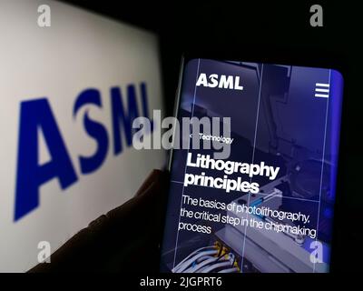 Persona che detiene il cellulare con pagina web della società olandese di semiconduttori ASML Holding N.V. sullo schermo con logo. Concentrarsi sul centro del display del telefono. Foto Stock