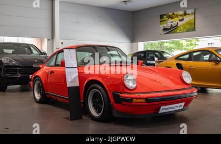 Un'immagine di una Porsche 911 Carrera 3,0 rossa all'interno di una concessionaria. Foto Stock