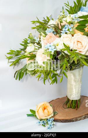 Bouquet Brides e abito coordinato boutonniere con rose e piccoli fiori blu, vista ritagliata con spazio copia. Foto Stock