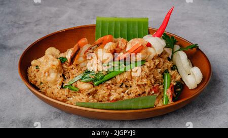 Pollo cinese Kung Pao e gamberi, primo piano in una ciotola su sfondo rustico grigio. Cucina tradizionale cinese tailandese ristorante Foto Stock