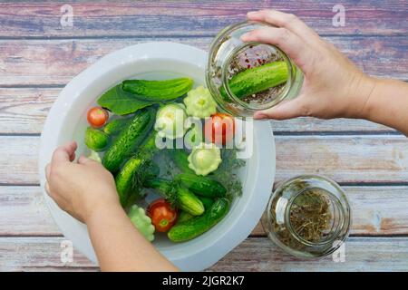 Cetrioli e pomodori da decapaggio in vasetti di vetro. Foto Stock