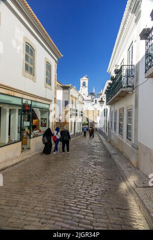 Turisti a piedi per l'Arco da Vila Faro Portogallo uno dei cancelli originali nella città vecchia di Faro l'Algarve Portogallo, due Storks Stand sulla parte superiore T. Foto Stock