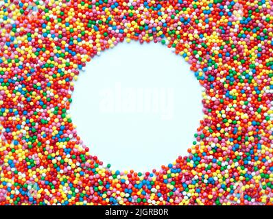 Palline di zucchero colorate su sfondo bianco a forma di cornice rotonda. Usato per decorare dolci e dolci. Posiziona per testo Foto Stock