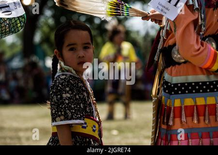 Kahnawake, Canada. 10th luglio 2022. Bambini in attesa del loro turno in arena durante il festival. Gli echi annuali del 30th di un fiero Pow-Wow Nation hanno portato migliaia di persone da tutto il Nord America per celebrare la cultura e le tradizioni dei nativi nella riserva di Mohawk di Kahnawake. Dopo due anni di hiatus, il più grande aratro del Quebec ha offerto un tempo per incontrarsi, ballare, cantare, visitare e festeggiare con amici e familiari. Credit: SOPA Images Limited/Alamy Live News Foto Stock