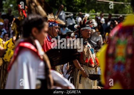 Kahnawake, Canada. 10th luglio 2022. I partecipanti al Pow-wow aspettano il loro turno nell'arena durante il festival. Gli echi annuali del 30th di un fiero Pow-Wow Nation hanno portato migliaia di persone da tutto il Nord America per celebrare la cultura e le tradizioni dei nativi nella riserva di Mohawk di Kahnawake. Dopo due anni di hiatus, il più grande aratro del Quebec ha offerto un tempo per incontrarsi, ballare, cantare, visitare e festeggiare con amici e familiari. Credit: SOPA Images Limited/Alamy Live News Foto Stock