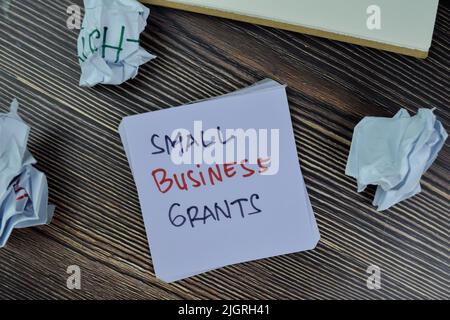 Concetto di piccole imprese borse scrivere su note appiccicose isolato su tavola di legno. Foto Stock