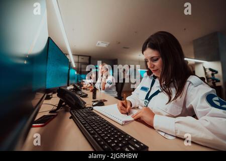 Gruppo di operatori di sicurezza femminile che lavorano in una sala di controllo del sistema di dati operatori tecnici che lavorano alla workstation con più display, sicurezza Foto Stock