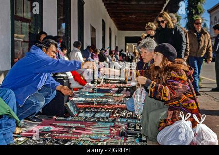 I gioiellieri nativi americani offrono articoli in vendita presso un negozio di marciapiedi all'aperto in una mattinata di sole a Santa Fe, NM. Foto Stock