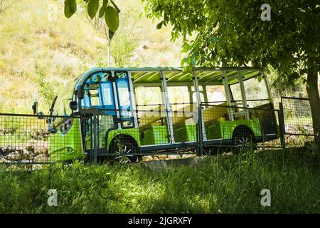 Vardzia, Georgia - 10th luglio, 2022: Mini mus verde in discesa con il turista a prendere per il trasferimento alla città grotta di Vardzia - famoso punto di riferimento turistico Foto Stock