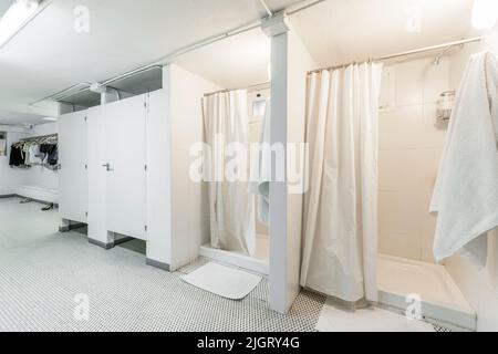 Docce con tende, servizi igienici con porte e spogliatoio in un armadietto Foto Stock