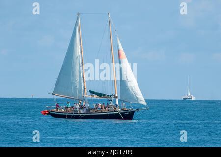 Key West, Florida - Maggio 13 2022: Una goletta di vela porta i turisti al largo della costa di Key West Florida per una crociera diurna sull'oceano. Foto Stock