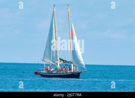 Key West, Florida - Maggio 13 2022: Una goletta di vela porta i turisti al largo della costa di Key West Florida per una crociera diurna sull'oceano. Foto Stock